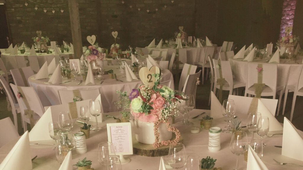 Heiraten auf dem Ponyhof mit festlich gedeckten Tischen in der Scheune