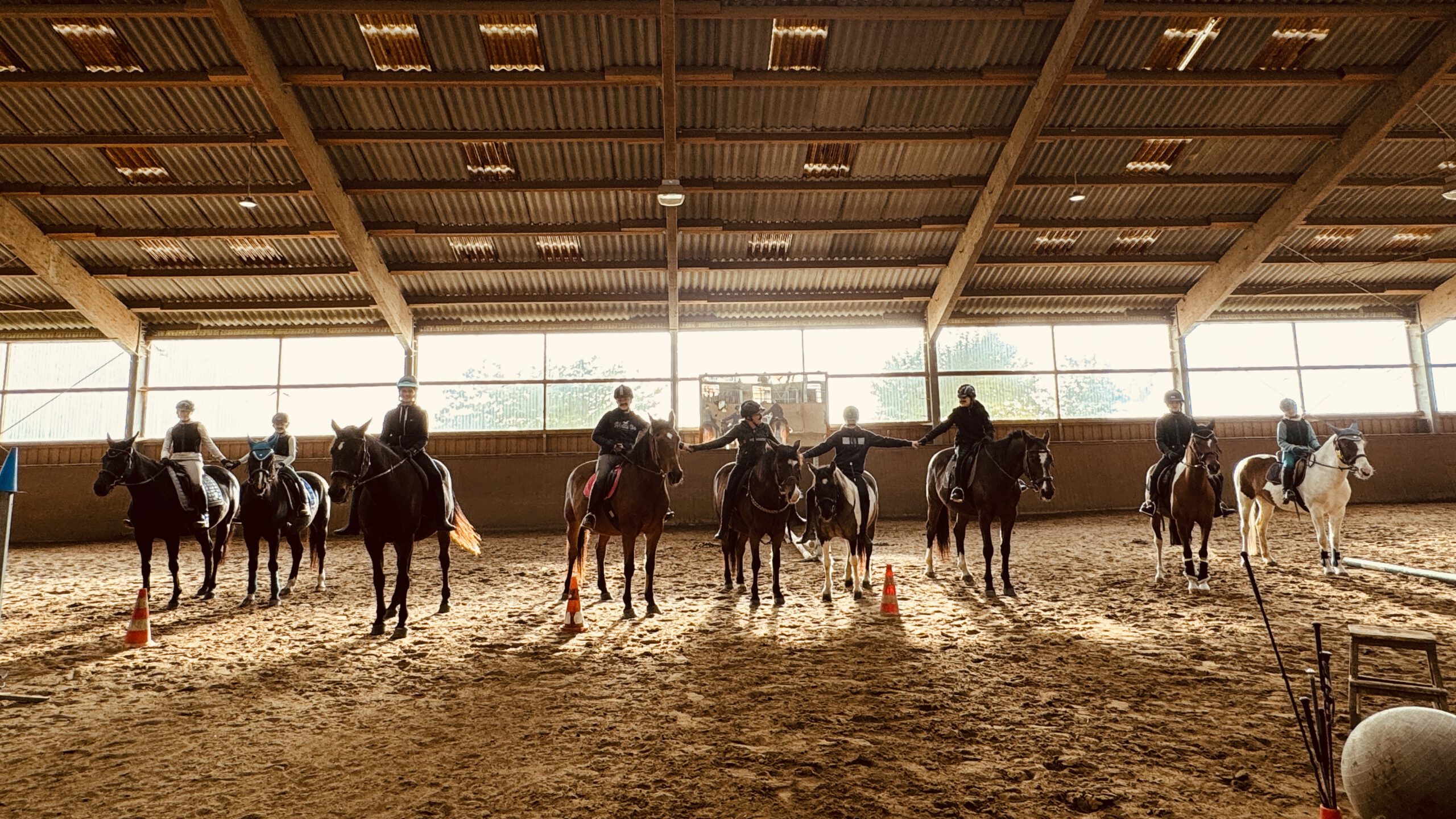 Reitschüler auf ihren Pferden in der Reithalle